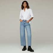 lady in white top and pants on a plain background