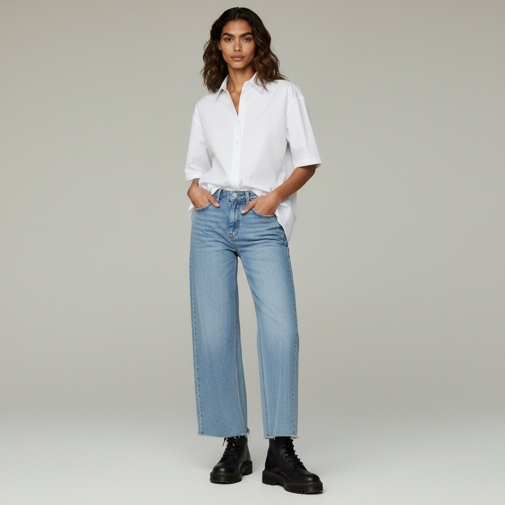 lady in white top and pants on a plain background